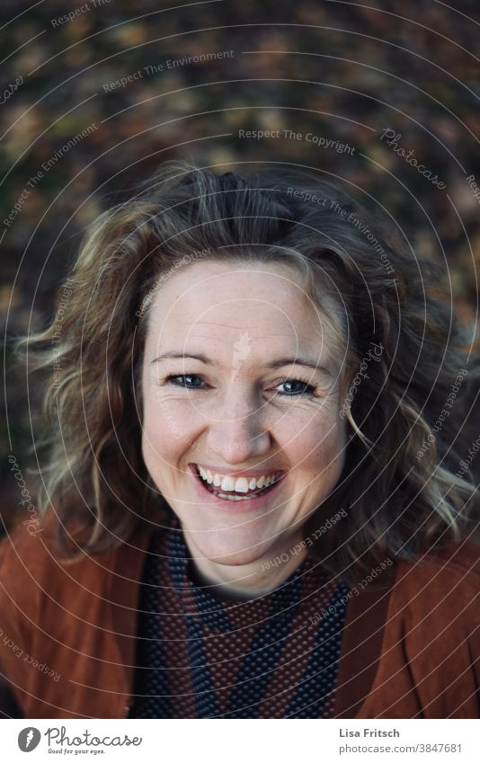 WOMAN LAUGHING BETWEEN LEAVES Woman Curl Blonde Hair and hairstyles Autumn foliage Brown Autumnal autumn colours Laughter Happiness Adults Exterior shot Joy