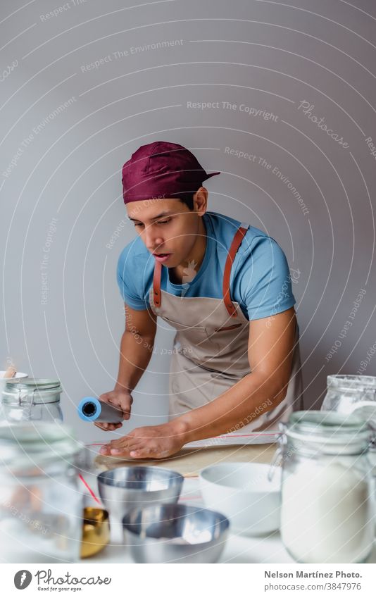 Man kneading dough over a white table. adult man indoor cooking flour chef restaurant employment food Eggs bakery desserts butter salt home home made healthy