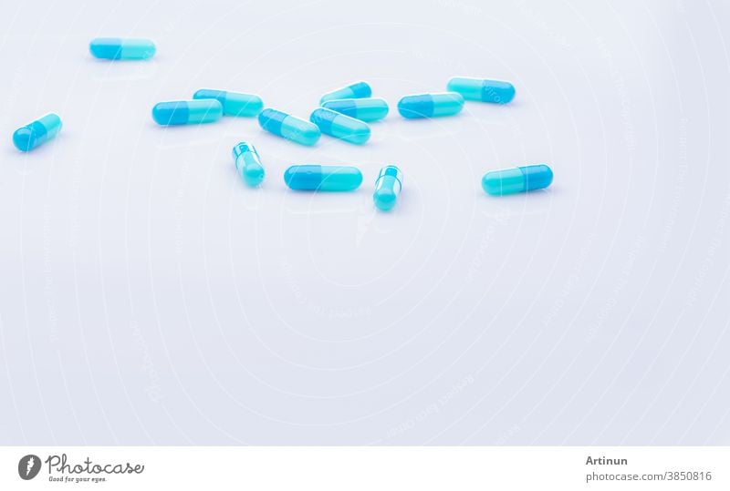 Selective focus on blue capsule pill on white background. Pharmaceutical industry. Pharmacy products. Healthcare and medicine. Blue capsule pills with beautiful patterns. Pharmaceutical manufacturing.