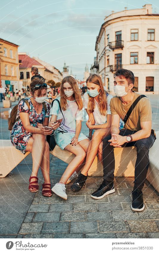 Young women spending time together sitting in the city center wearing the face masks to avoid virus infection caucasian conversation covid-19 female lifestyle