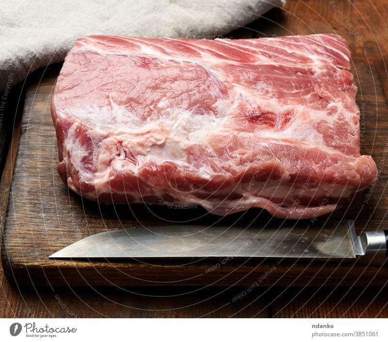 raw pork tenderloin on a wooden cutting board meat napkin nutrition piece portion preparation protein red sirloin butcher chop closeup cuisine dinner fat filet