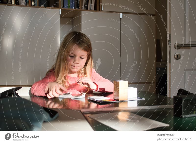 Caucasian Girl Playing on Table Indoors child girl play blond caucasian lifestyle female indoor natural lighting grow learn arts and crafts room table