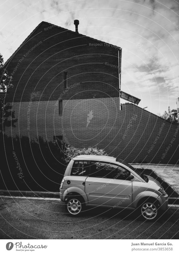 Very small car parked in front of brick house facade very small Tall vehicles Street Car Traffic infrastructure Approach road Parking lot Small Diminutive