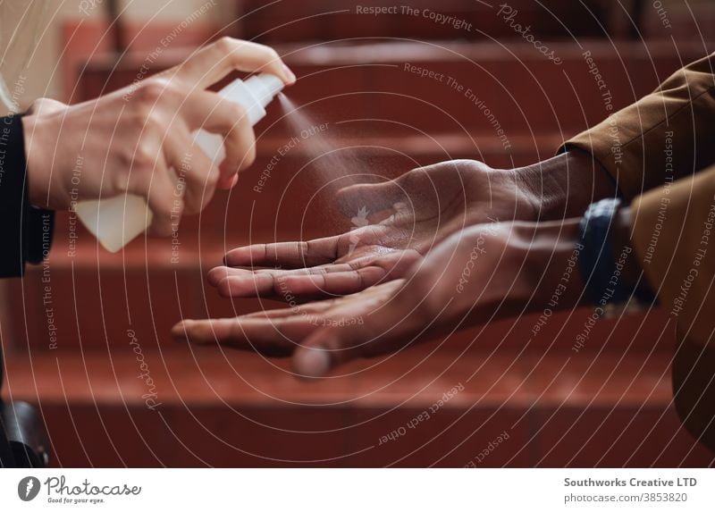 Close Up Of Businessman Having Hands Sprayed With Sanitiser During Health Pandemic business businessman office worker sanitizer hand sanitizer sanitizing