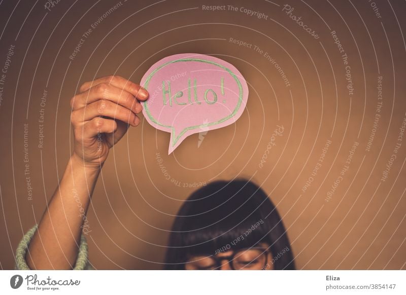 Woman with a speech bubble with hello written in English Hello Welcome Foreign language Communicate Neutral Background authored Word hello! stop attention