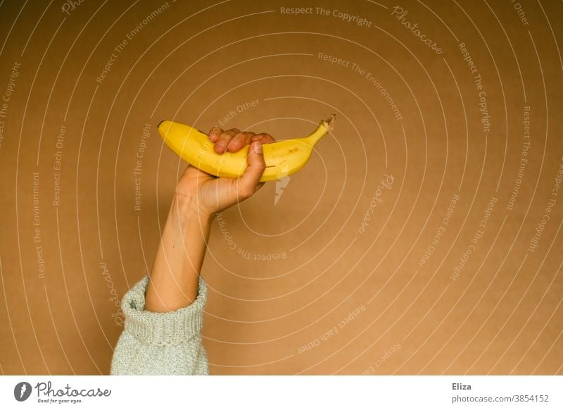 One person still holds a banana Banana Hand fruit salubriously Healthy Eating Yellow stop Woman Neutral background