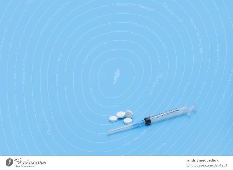 Syringe and white pills on a blue background. Place for your text. Medical background. medical syringe stethoscope medicine illness health cure prescription