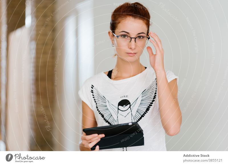 Young smart woman with tablet using room data casual young online female glasses internet modern device gadget browsing surfing lifestyle watch social media