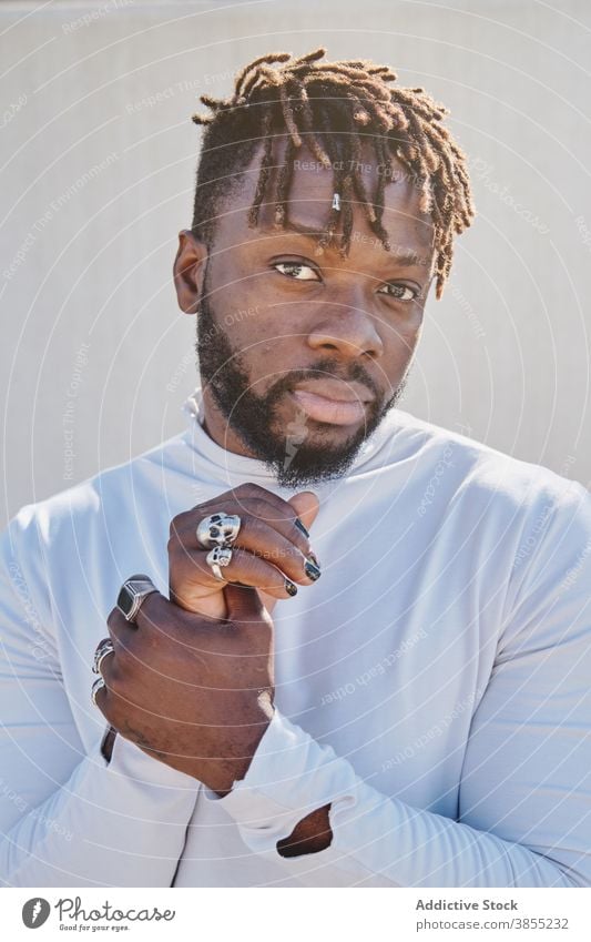 Stylish black man with unusual appearance dreadlocks manicure fancy style hairstyle ring hipster portrait male ethnic african american fashion trendy cool