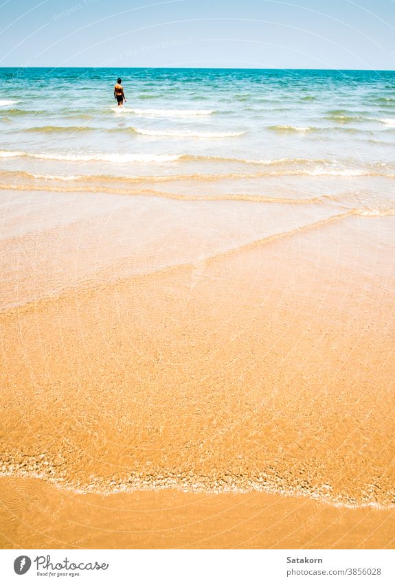 Unidentified man and the bubble of sea wave on the beach blue sand splash reflection water nature texture people tropical sky background beautiful white