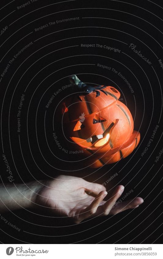 Floating halloween pumpkin orange fall autumn seasonal october decoration levitation jack o lantern Magic Hand black background Dark holiday celebration