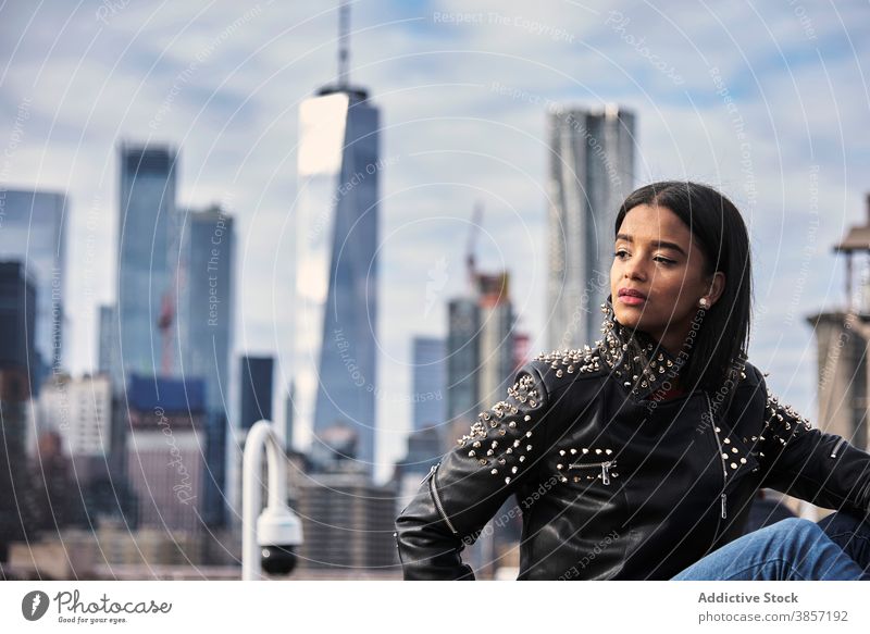 Pensive woman relaxing on city street downtown dreamy pensive thoughtful leather jacket style female ethnic black african american usa united states new york