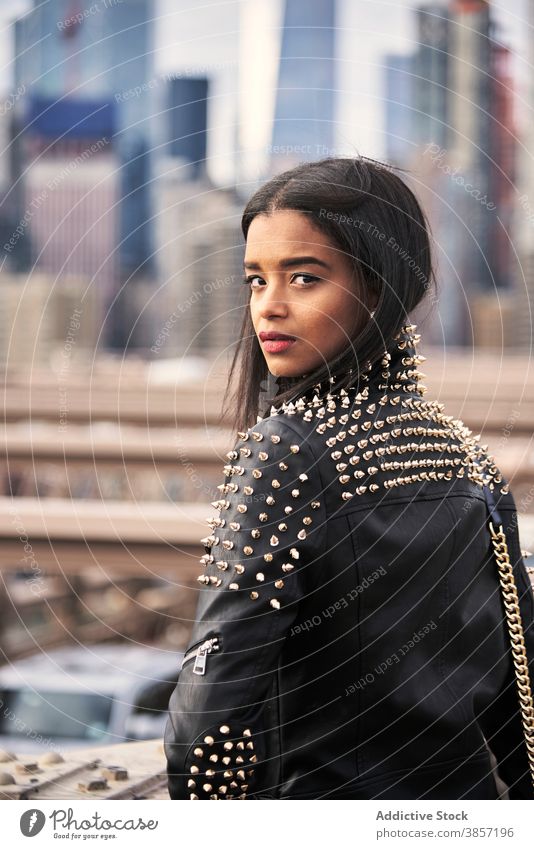 Pensive woman relaxing on city street downtown dreamy pensive thoughtful leather jacket style female ethnic black african american usa united states new york