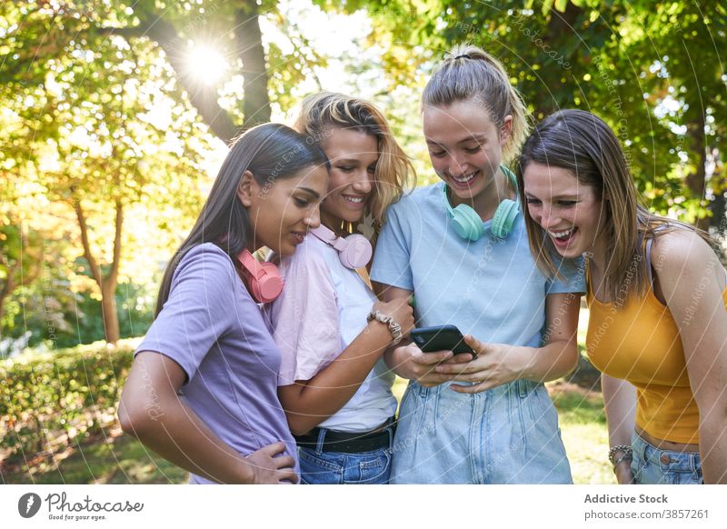 Group of female hipsters with smartphone walking in city girlfriend using discuss street share together mobile cheerful laugh happy urban group show demonstrate