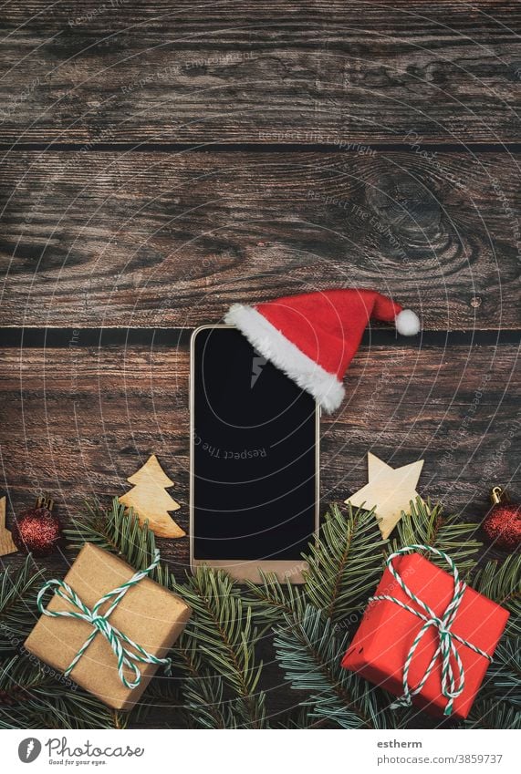 Christmas concept background.Smartphone with santa claus hat and Christmas tree branches christmas christmas tree smartphone christmas background christmas eve