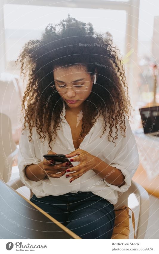 Serious black businesswoman using smartphone at home entrepreneur busy freelance remote work office online female ethnic african american serious device job