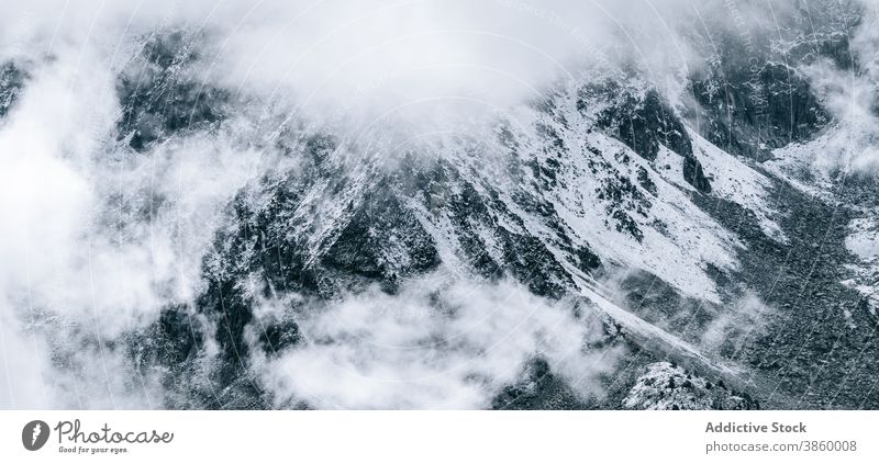 Rocky mountain ridge covered with snow rock range rough slope peak cloud panorama cold majestic scenery rocky nature landscape altitude environment picturesque