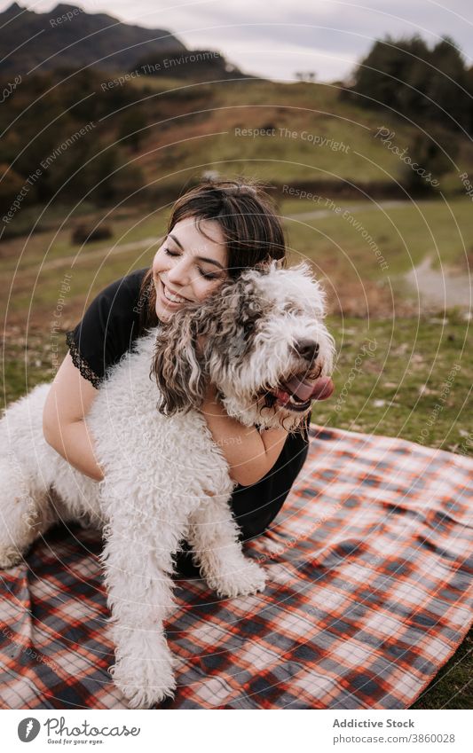 Smiling woman hugging dog in nature owner cuddle friendship spanish water dog together enjoy blanket weekend pet animal canine embrace bonding sit obedient