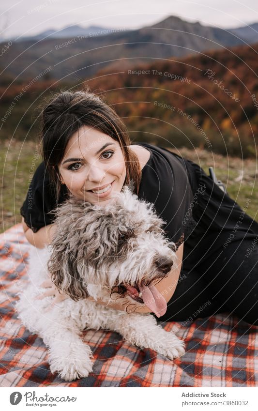 Smiling woman hugging dog in nature owner cuddle friendship spanish water dog together enjoy blanket weekend pet animal canine embrace bonding sit obedient