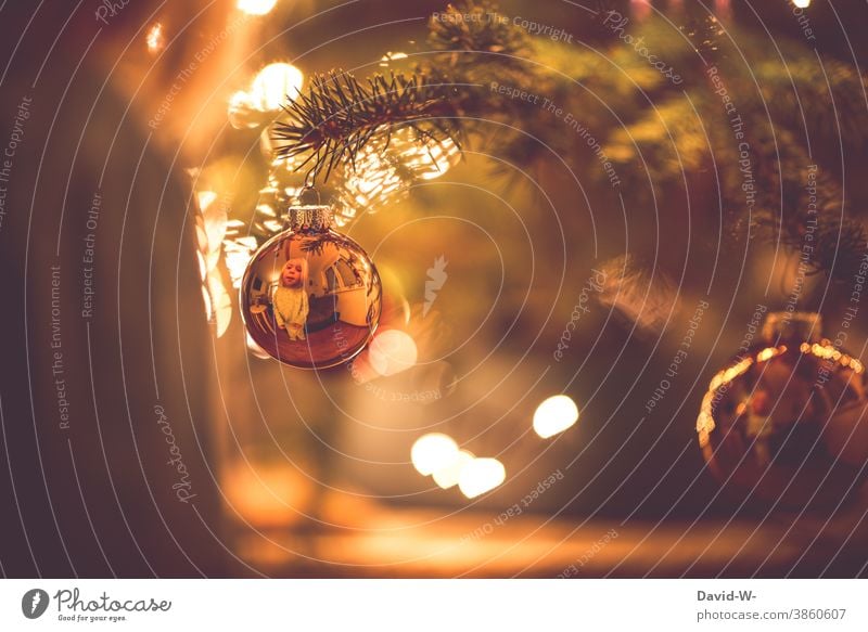 Christmas - Child looks joyfully into a Christmas tree ball and discovers its reflection Christmas & Advent Glitter Ball Mirror image mirror Cute Anticipation