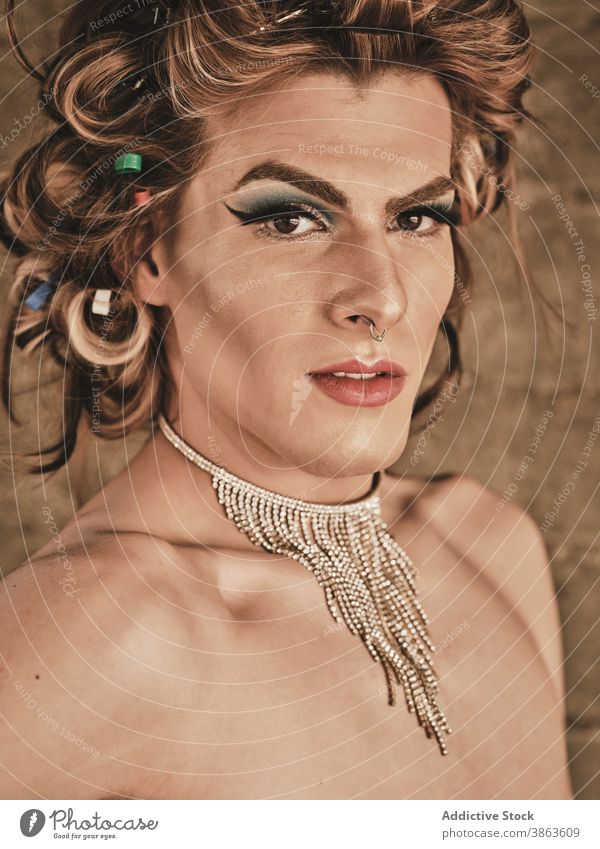 Drag queen with necklace looking at camera man transgender makeup elegant appearance androgynous hairstyle luxury portrait shirtless male young model glamour