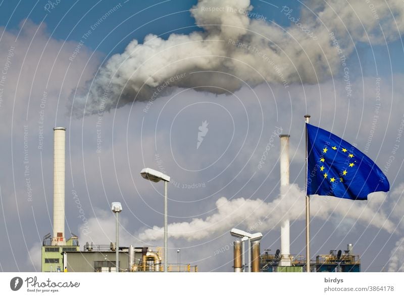 Smoking industrial chimneys . Factory with European flag in front of it .European Union CO2 emission EU Industrial plant Chimney Smoke Air pollution