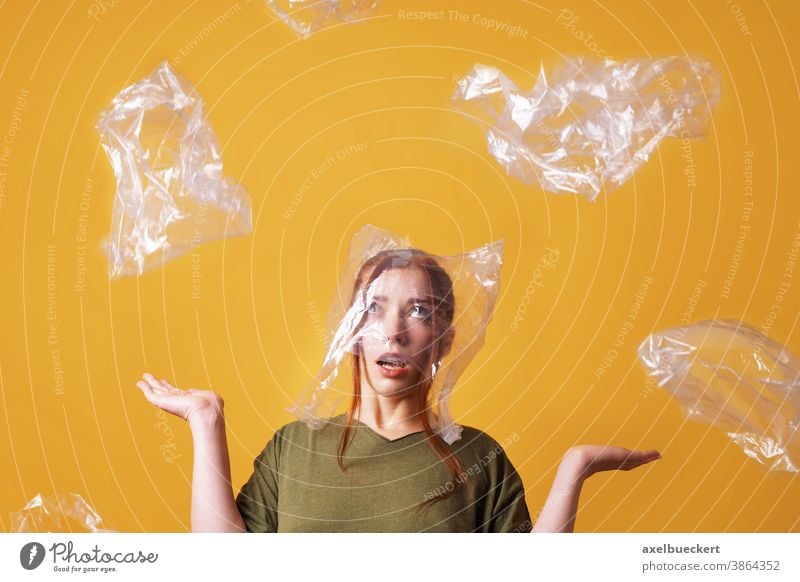 woman overwhelmed by plastic waste and suffocating from plastic bag over her head - ecology and pollution concept suffocate person garbage environment trash