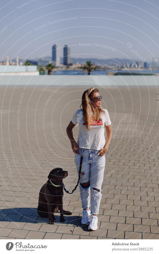 Woman walking along street with dog woman owner leash city female labrador retriever cute stroll obedient pandemic companion domestic friend canine animal young