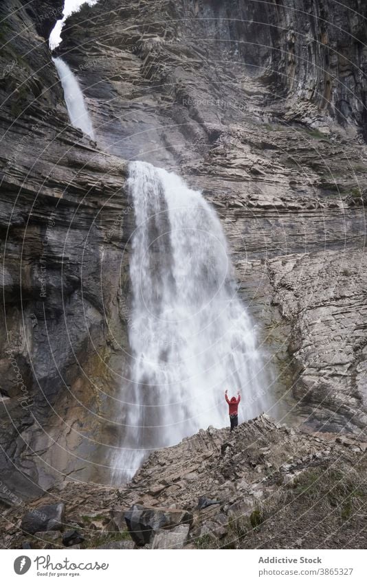 Man in majestic waterfall in mountainous area man pyrenees flow landscape highland picturesque hill rock ordesa valley spain rocky sunny nature destination