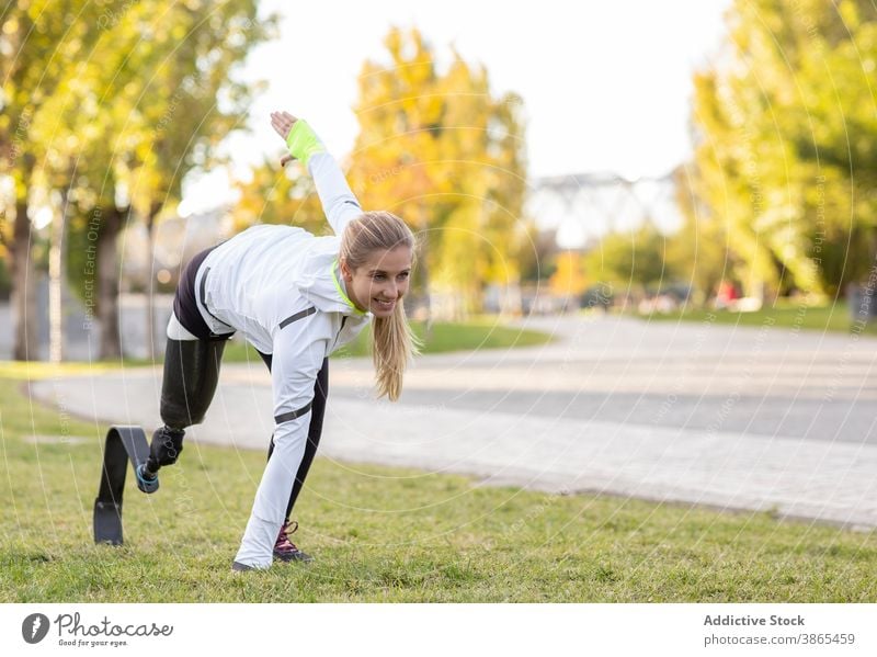 Athletic woman with artificial limb of leg training in park explosive start runner paralympic prosthesis sportswoman female exercise bionic ready prepare