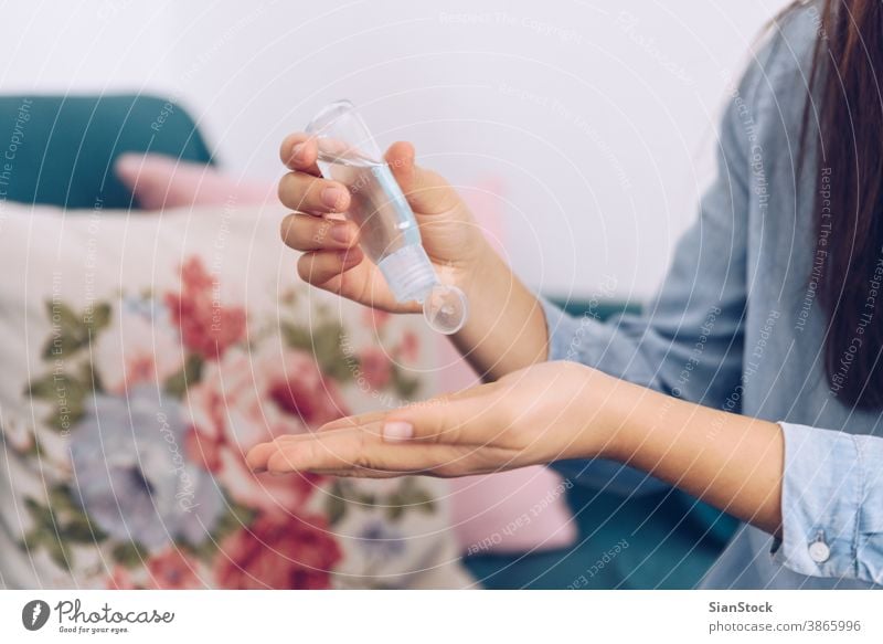 Coronavirus concept. Girl in her home put antiseptic gel on her hands for protection from coronavirus. Global call to stay home. covid quarantine 2019-ncov