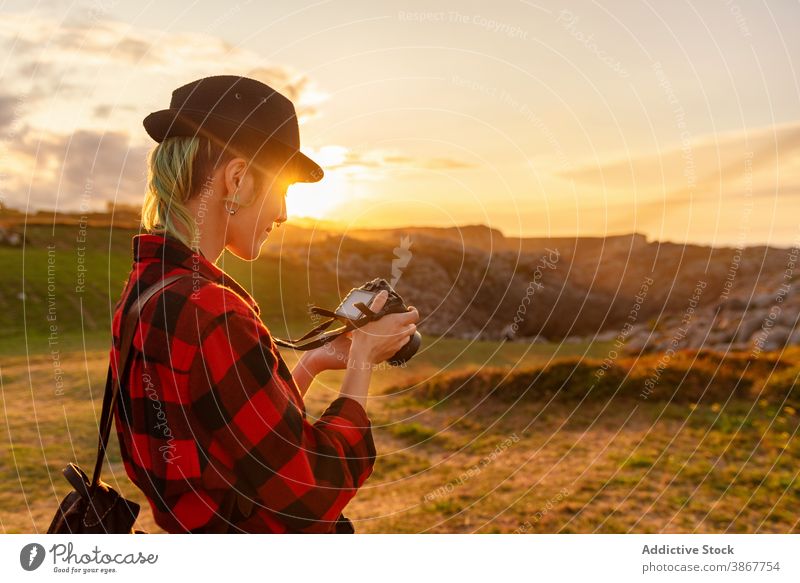 Photographer on hill at sunset travel photographer woman traveler photo camera explore adventure androgynous female alternative gender professional nature area