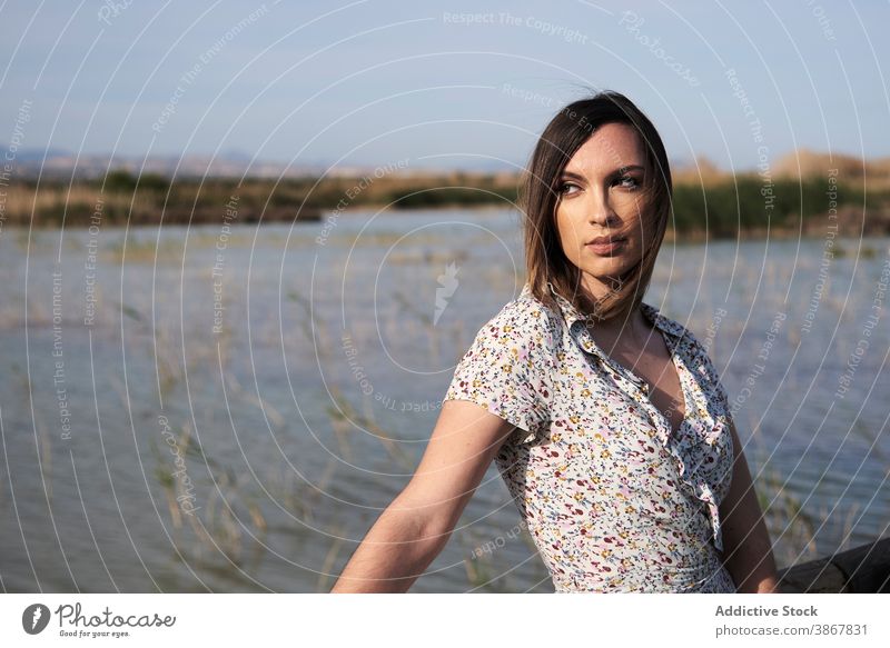 Woman standing on wooden bridge over lake woman boardwalk pier alone summer nature river water rest calm vacation tranquil countryside serene female lifestyle