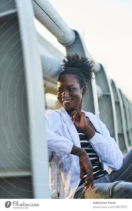 Smiling African American woman resting on street smile cheerful happy urban young enjoy positive content afro black female student african american ethnic