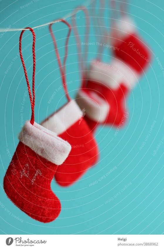 several small Santa boots hang on a rope in front of a turquoise background Santa's boots Christmas Santa Claus Advent Christmas & Advent Christmas decoration