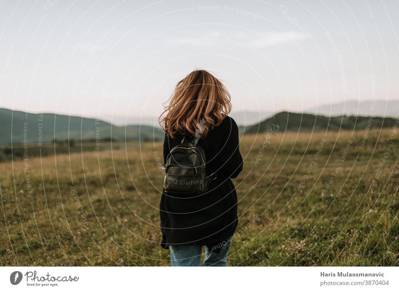 Woman with backpack walking in nature adventure beautiful beauty behind blonde concept digital nomad dress energy explore exploring exploring the world fashion