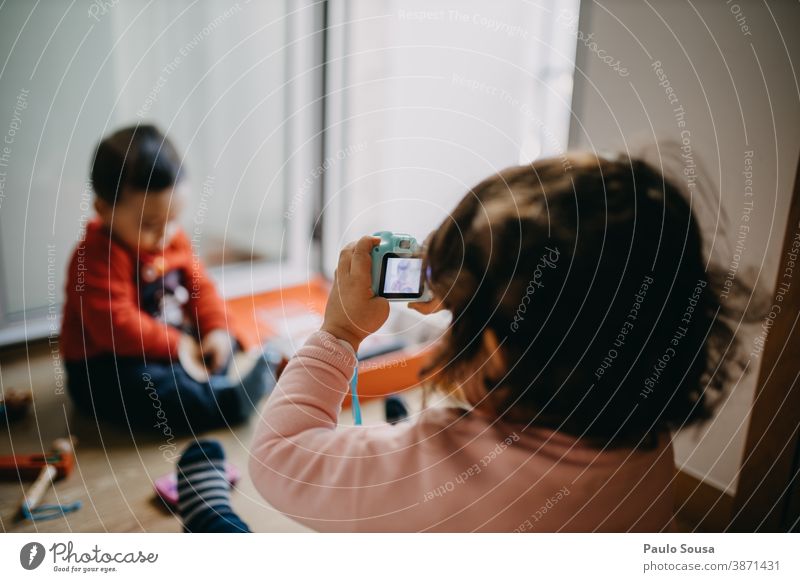 Sister taking pictures of her brother 0-09 years Know Learn Learn and Know Lifestyle affectionate at home authentic casual caucasian child color curiosity