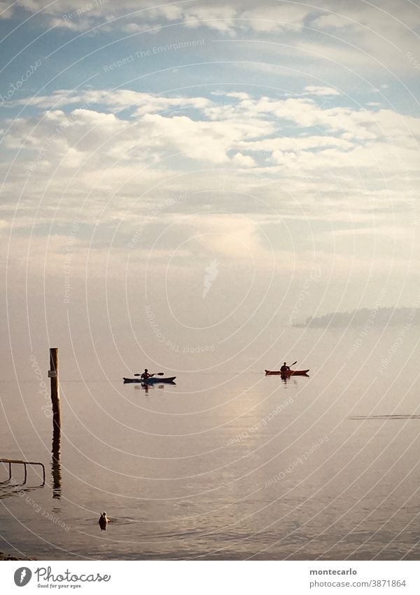 Two paddlers on Lake Constance in November Exterior shot Cold silent Autumn foggy Calm hazy somber Colour photo Day sight Moody Canoes canoe boat Sky Clouds