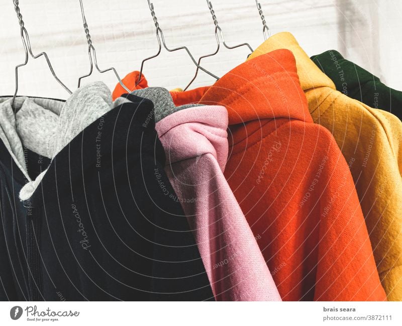 Multi colored sweatshirts on the coat rack fashion colours clothes clean laundry multicolor background colors shopping center home elegance ripple cotton