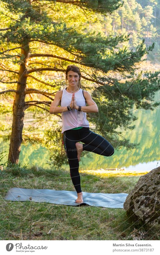 Woman practices yoga alone in the forest Back view Outdoor activity Young attractive Asian woman practicing yoga, exercising exercising working out Women is meditating alone at sunrise.