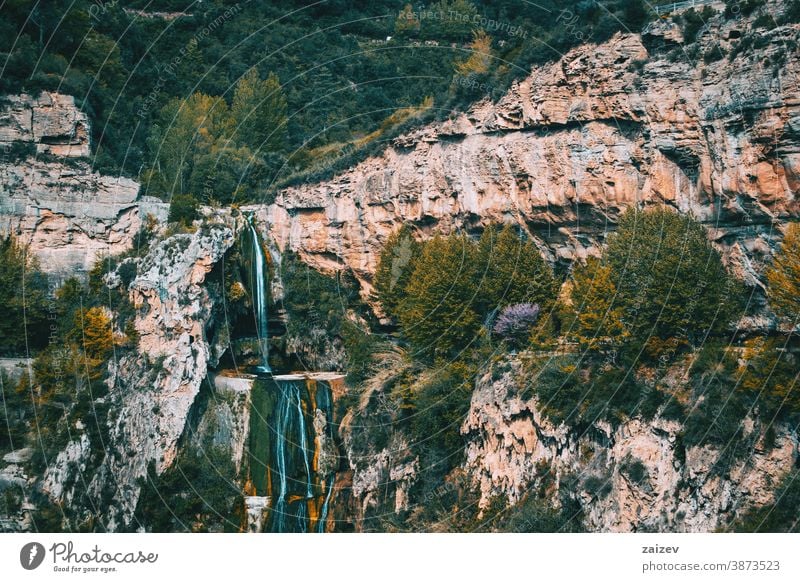 Views of a waterfall flowing through some steep walls of a mountain Cingles de Bertí Riscos de Berti sant miquel del fai landscape mountains trees grove nature