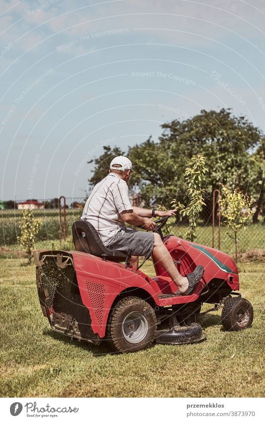 Man mowing his lawn using riding lawnmower occupation seasonal cut trimming man job person field professional ride gardener drive equipment worker male