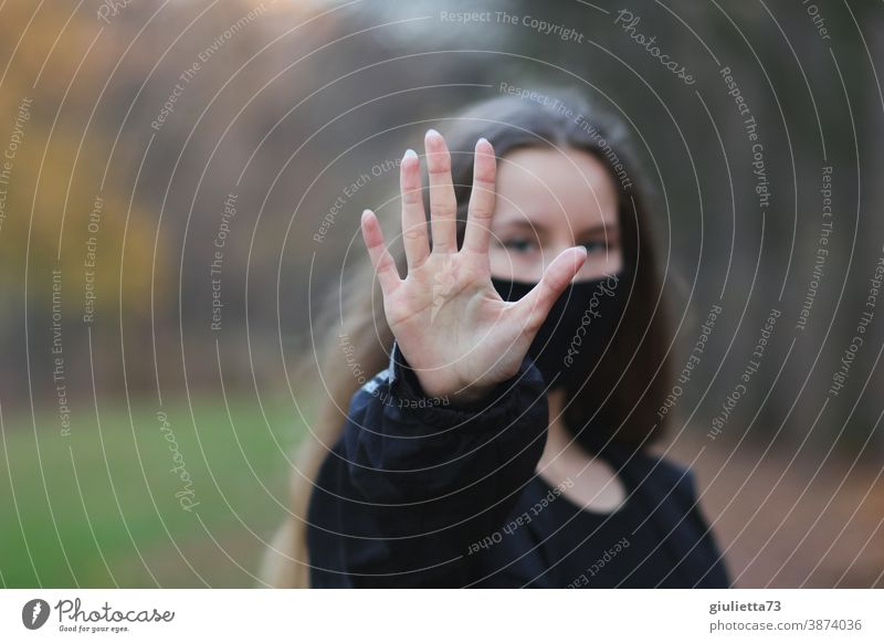 Teenage girls symbolizes: No - stop - stop by reaching out her hand in front of her Hold Hand gap Protection Looking into the camera Front view Upper body