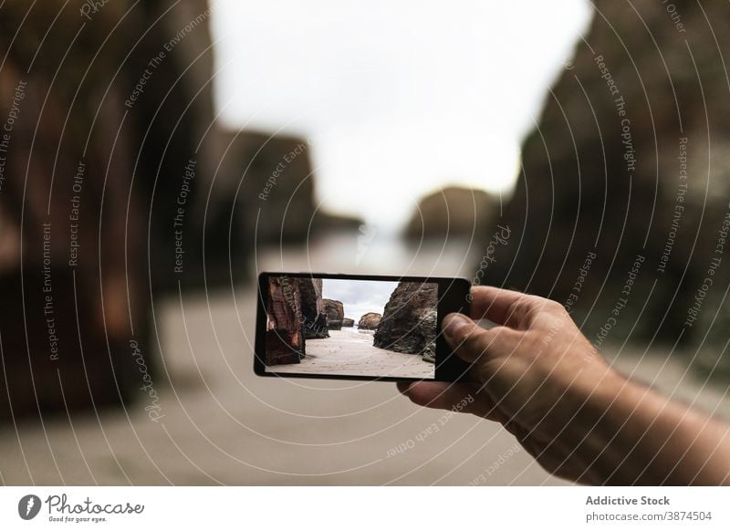 Traveler taking picture of rocky seashore traveler take photo smartphone coast hand beach shoot photography capture screen ocean male nature mobile gadget