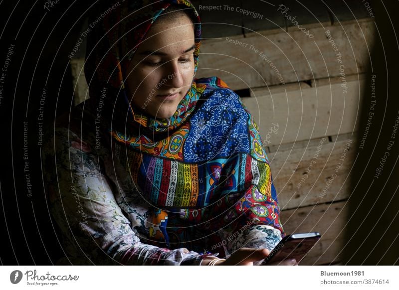 Portrait of an attractive teenage Muslim girl working with smart phone portrait white thinking bright casual people Caucasian cute dress healthy beauty lovely