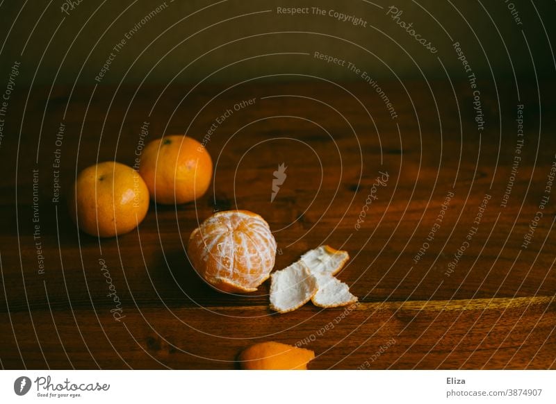 Three mandarins, one peeled, on a wooden table Table salubriously Winter Advent fruit Vitamin C Healthy Food Vitamin-rich Orange clementine Fresh Healthy Eating