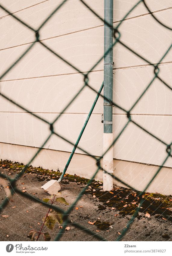 Industrial facade with pipes photographed through a fence Industry Architecture Industrial hall Industrial area Factory Factory hall lines minimalism Concrete