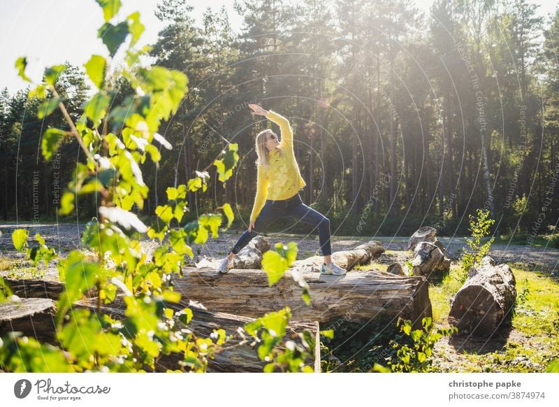 Woman doing yoga on a tree trunk in the forest Yoga Forest Tree trunk Green Environment Nature Exterior shot Colour photo Day Sports Movement leaves Landscape