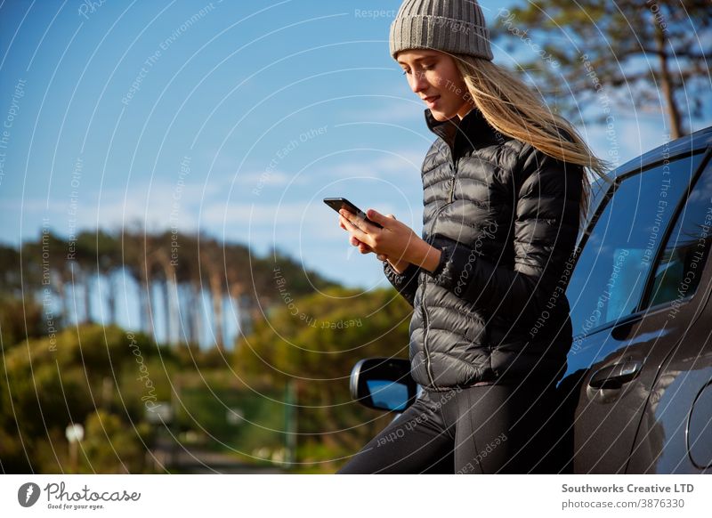 Young Woman Standing Next To Broken Down Car Trying To Get Signal On Mobile Phone car breakdown road trip woman young women holiday vacation broken down