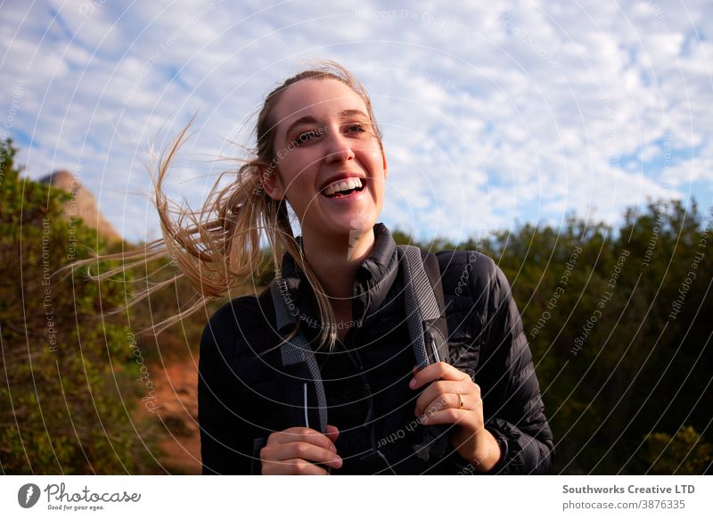 Portrait Of Young Woman With Backpack Hiking Along Path Through Countryside smiling woman young women hike hiking walk walking trek active backpack holiday